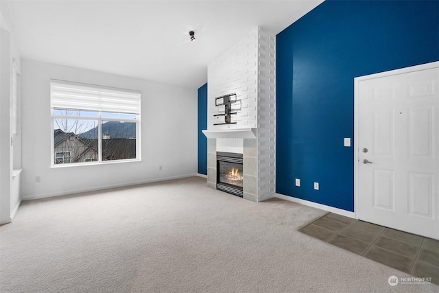 unfurnished living room with a fireplace, carpet floors, and vaulted ceiling