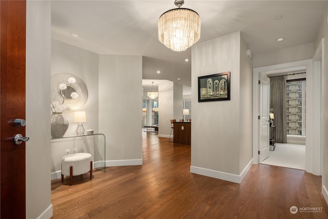 hall featuring hardwood / wood-style floors and a notable chandelier