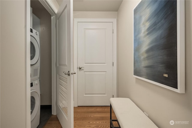 clothes washing area with stacked washer / drying machine and hardwood / wood-style flooring