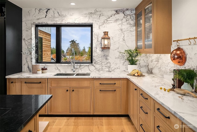 bar with light stone counters, sink, and tasteful backsplash