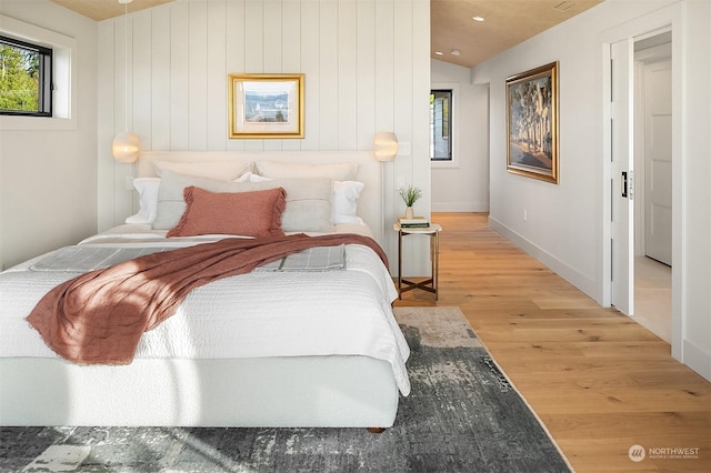 bedroom featuring light hardwood / wood-style floors and vaulted ceiling