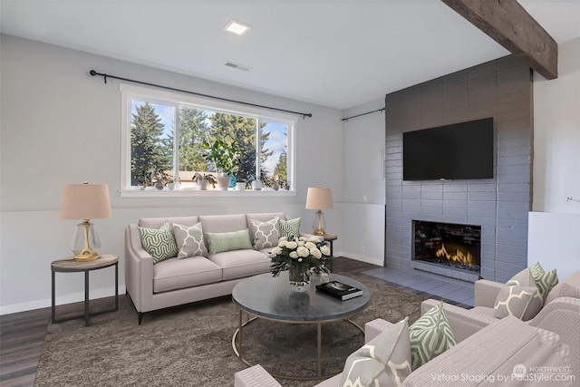 living room with a fireplace, beam ceiling, and dark hardwood / wood-style flooring