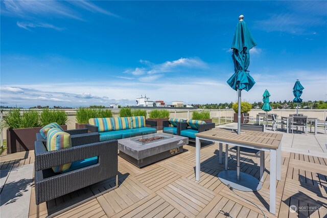 deck featuring an outdoor living space with a fire pit