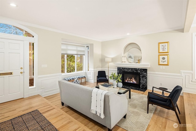 living room featuring hardwood / wood-style flooring, ornamental molding, and a fireplace