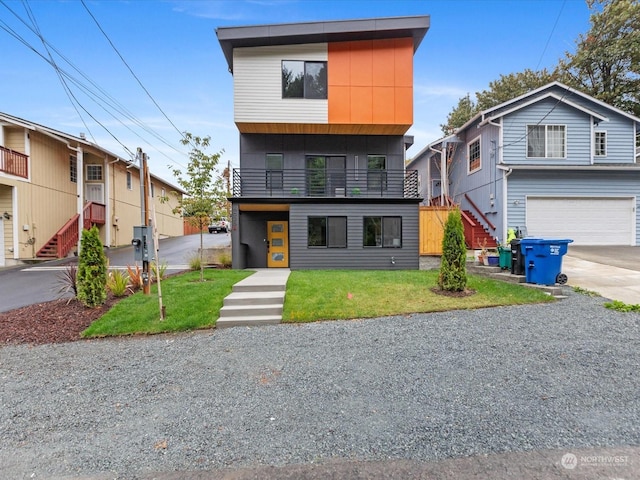 view of front facade with a balcony, a front yard, and a garage