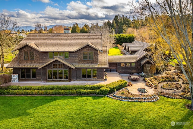 rear view of property featuring a patio area and a lawn