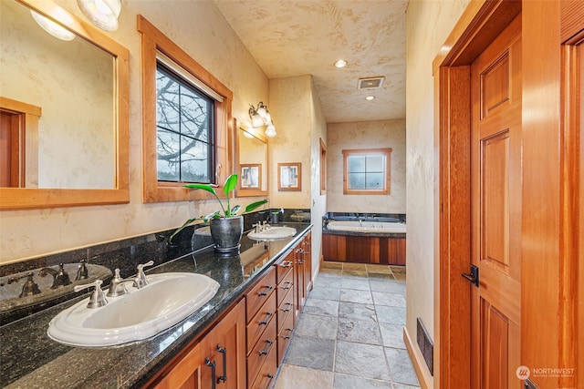 bathroom with vanity and a bath