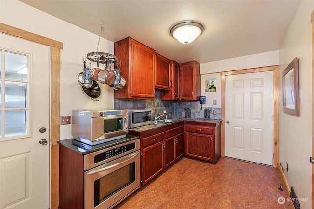 kitchen with appliances with stainless steel finishes, backsplash, and sink