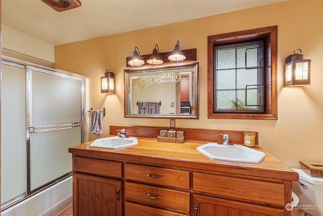 full bathroom with vanity, combined bath / shower with glass door, and toilet