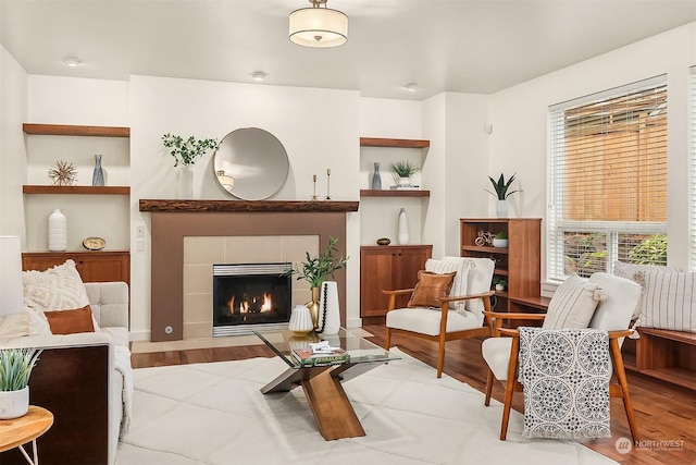 sitting room featuring light wood-type flooring and a tiled fireplace