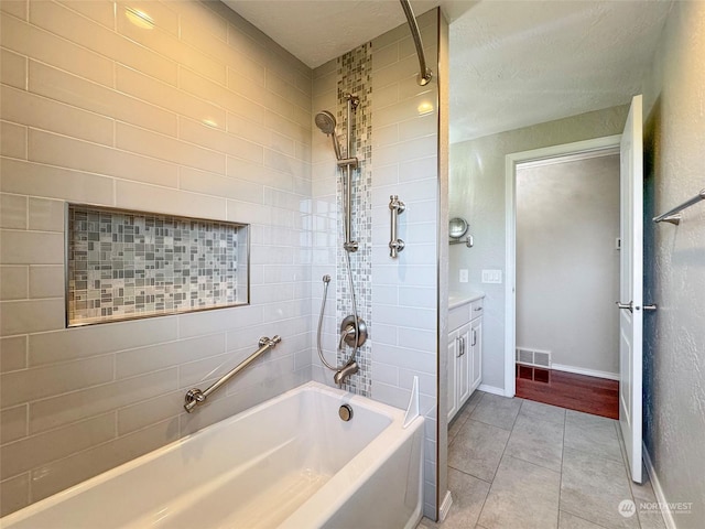 bathroom with vanity, tile patterned floors, and tiled shower / bath