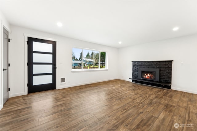 unfurnished living room featuring a fireplace and hardwood / wood-style flooring