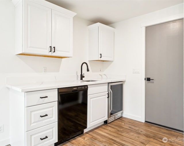 kitchen with sink, white cabinets, black dishwasher, light hardwood / wood-style floors, and wine cooler