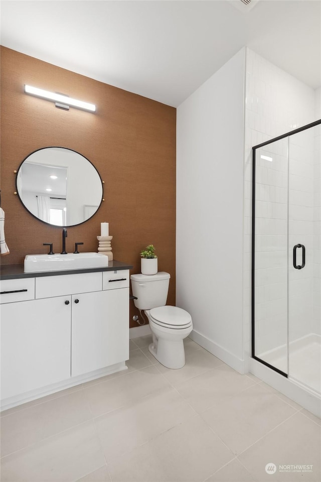 bathroom with tile patterned flooring, vanity, toilet, and walk in shower