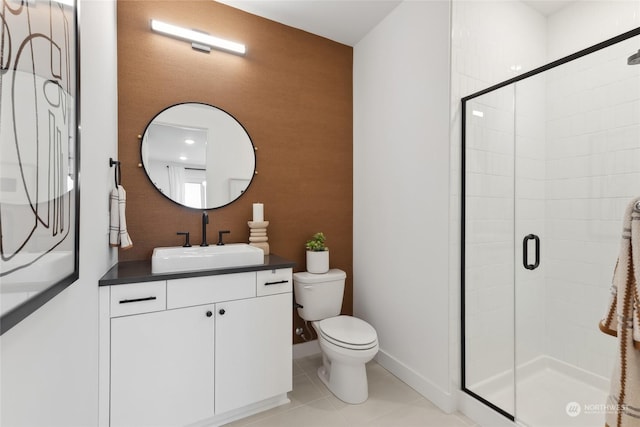 bathroom with tile patterned floors, vanity, toilet, and a shower with door