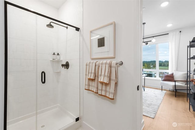 bathroom with wood-type flooring and an enclosed shower