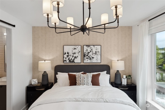 bedroom featuring connected bathroom and a notable chandelier