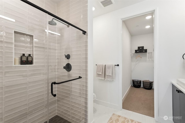 bathroom featuring vanity, toilet, and an enclosed shower