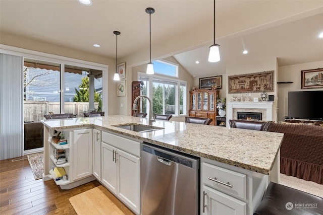 kitchen with dishwasher, white cabinetry, hanging light fixtures, and sink