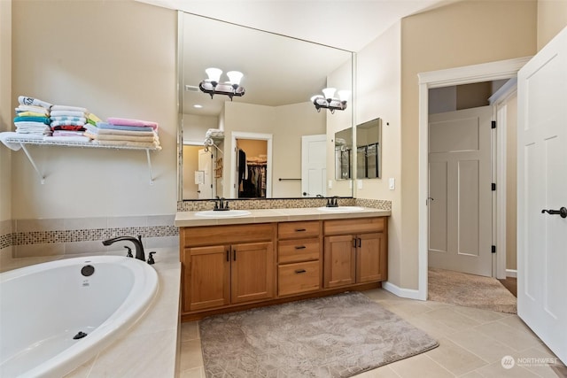 bathroom with tile patterned flooring, vanity, tiled tub, and an inviting chandelier