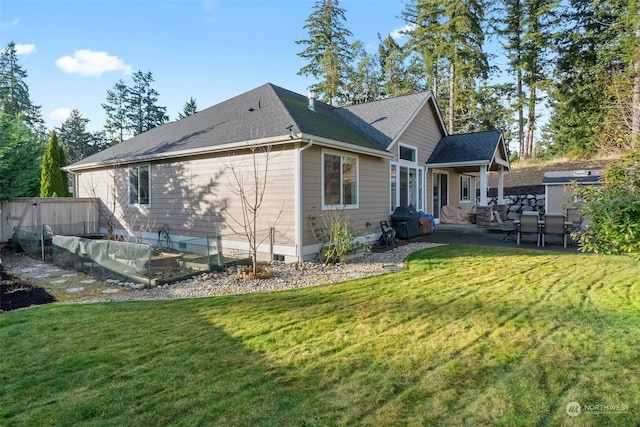 back of property with a lawn and a patio