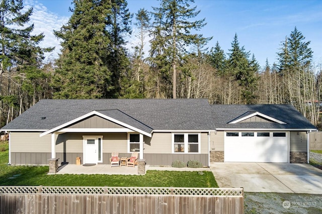 view of front facade featuring a garage, a patio, and a front yard