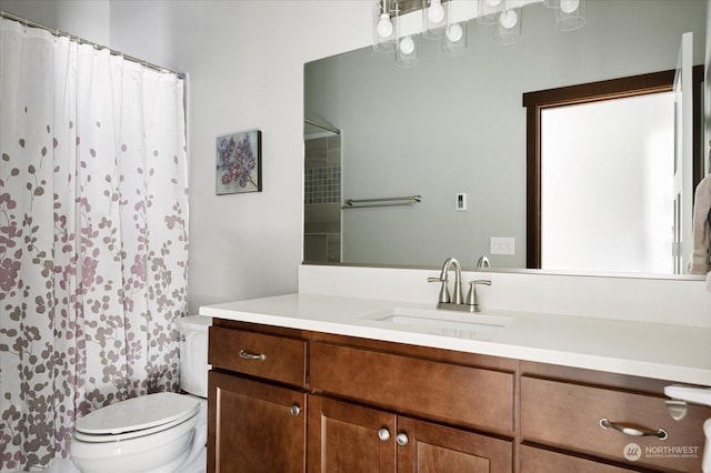 bathroom with curtained shower, vanity, and toilet