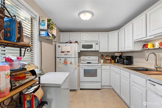 kitchen featuring white cabinetry, white appliances, and sink