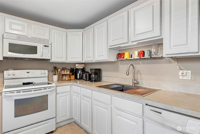 kitchen featuring white cabinetry, sink, and white appliances