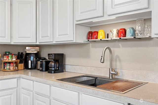 kitchen featuring sink and white cabinets