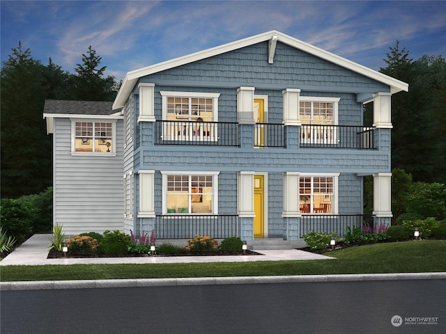 view of front of home featuring covered porch, a balcony, and a front lawn