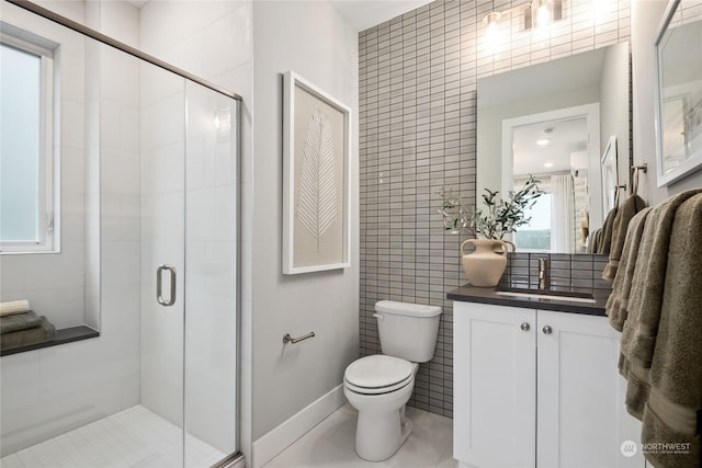 bathroom with vanity, toilet, a shower with door, and tile walls