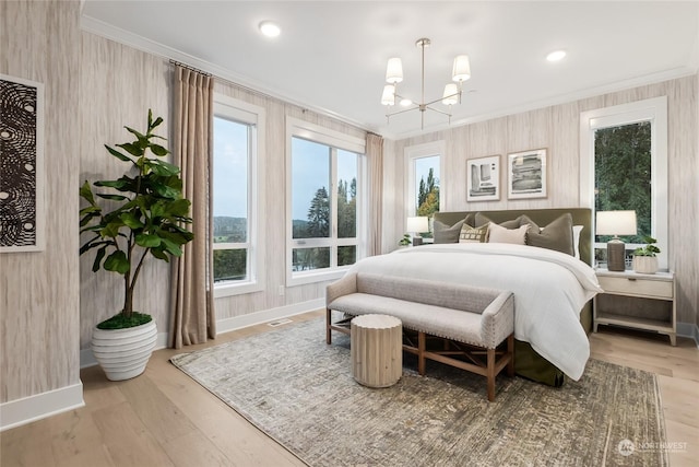 bedroom with wood-type flooring, ornamental molding, and a chandelier