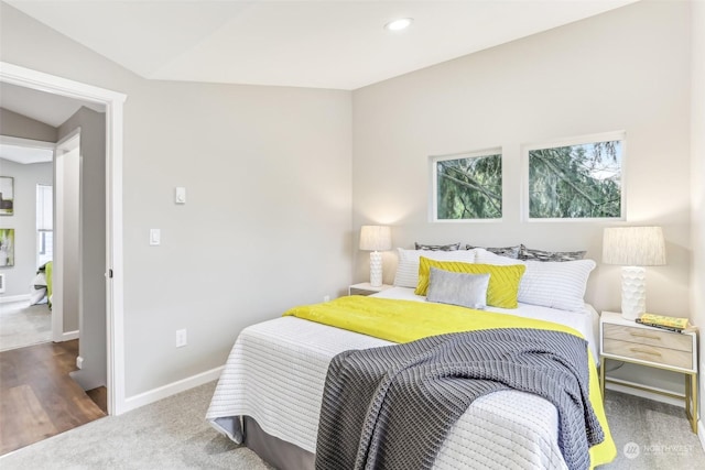 carpeted bedroom with lofted ceiling