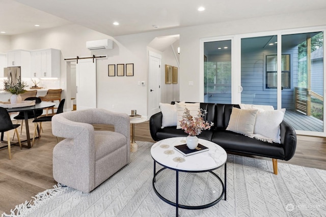 living room featuring a wall unit AC, a barn door, and light wood-type flooring