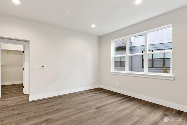 empty room with dark hardwood / wood-style floors and a wealth of natural light