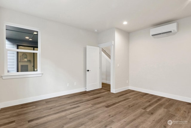 spare room with hardwood / wood-style floors and a wall mounted AC