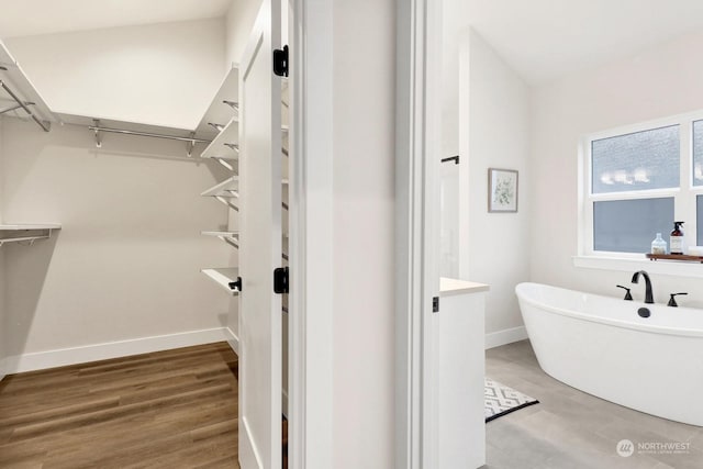 bathroom with hardwood / wood-style flooring and a bathtub