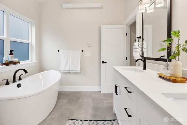 bathroom with a bath, vanity, tile patterned floors, and a healthy amount of sunlight