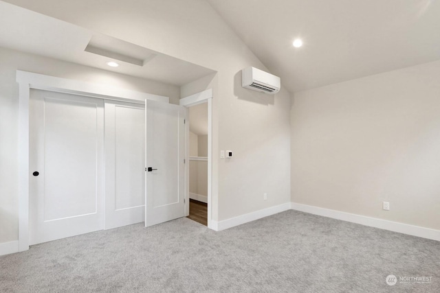 unfurnished bedroom with a wall mounted AC, light carpet, a closet, and vaulted ceiling