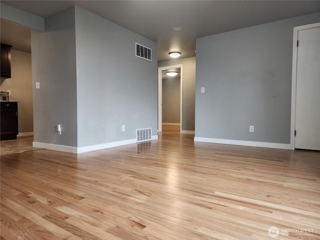 unfurnished room with light wood-style floors and visible vents