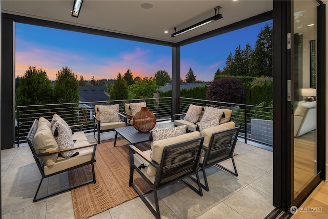 patio terrace at dusk with outdoor lounge area and a balcony