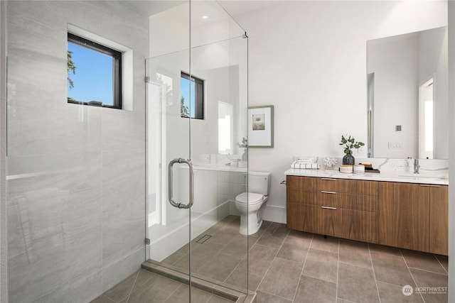 bathroom with tile patterned floors, vanity, toilet, and a shower with door