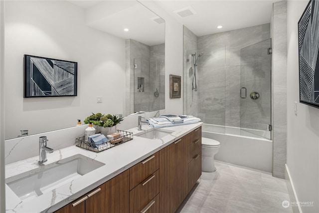 full bathroom featuring vanity, bath / shower combo with glass door, and toilet