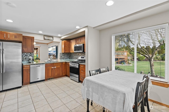 kitchen with decorative backsplash, light tile patterned floors, sink, and appliances with stainless steel finishes