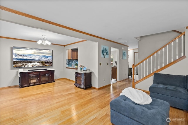 living room with an inviting chandelier, crown molding, and light hardwood / wood-style flooring