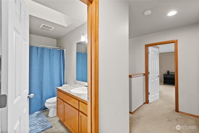 bathroom with vanity, toilet, and a skylight