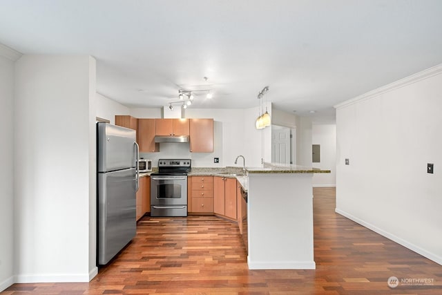 kitchen featuring kitchen peninsula, light brown cabinetry, light stone countertops, stainless steel appliances, and sink