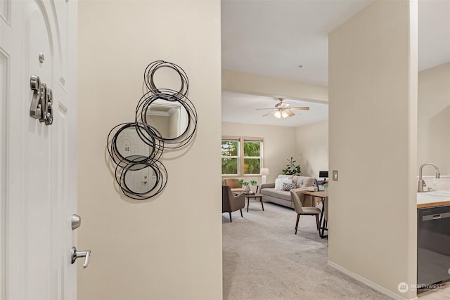 hallway with sink and light colored carpet