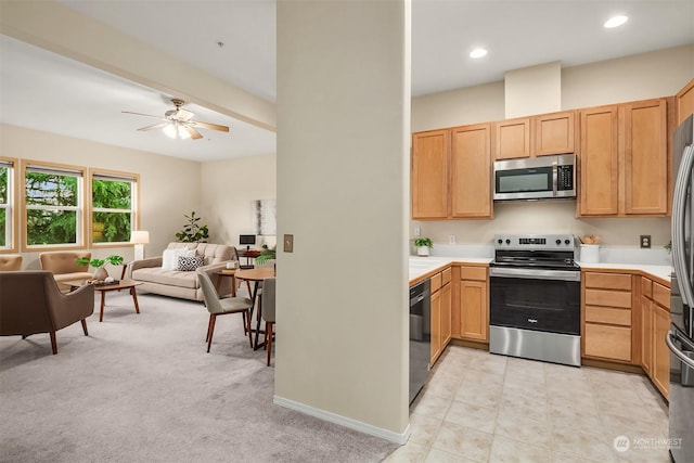 kitchen featuring ceiling fan, light brown cabinetry, light carpet, and appliances with stainless steel finishes